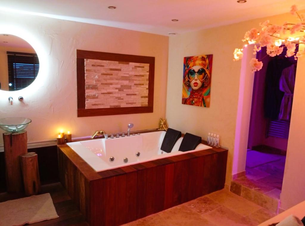 een grote badkamer met een groot bad in een kamer bij L' AmbriFany in Quelmes