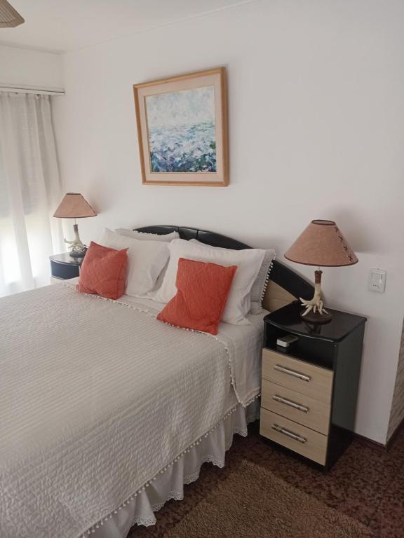 een slaapkamer met een bed met twee lampen op een nachtkastje bij peninsula fontemar in Punta del Este