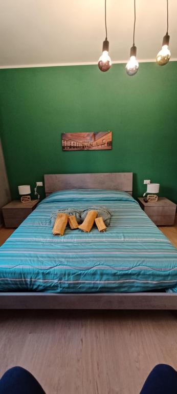 a green bedroom with a bed with two wooden slippers at Re Di Coppe in Torre Boldone