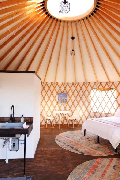 a room with a bed and a sink in a yurt at Johnny Yurts in Johnson City