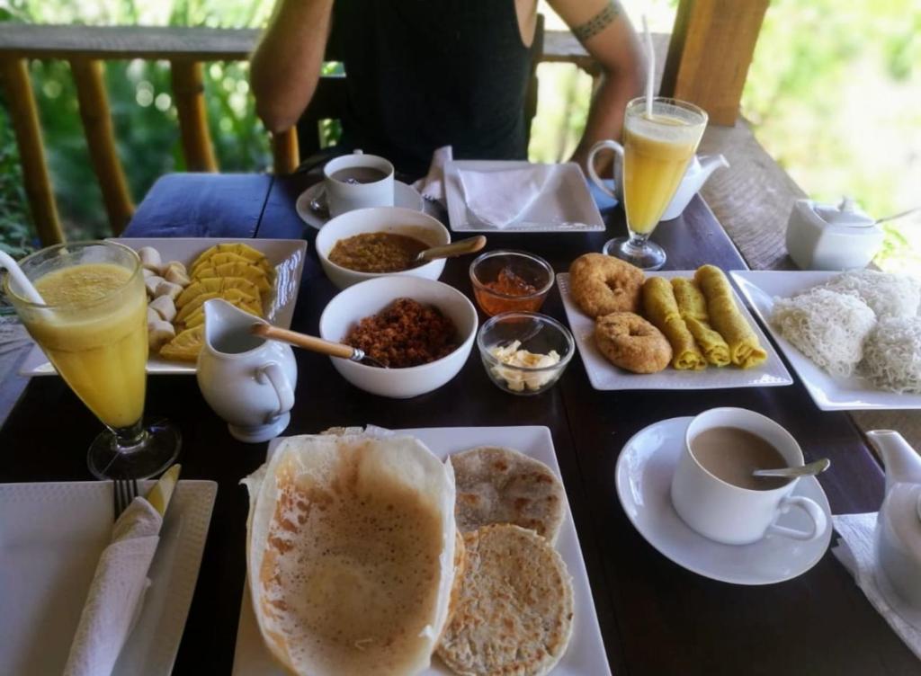 een tafel met ontbijtproducten en drankjes erop bij Slon White Elephant Ella in Ella