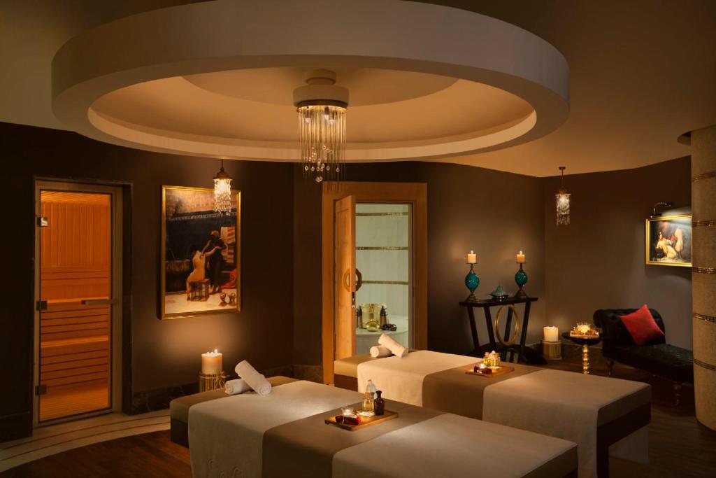 a living room with two beds and a chandelier at CVK Park Bosphorus Hotel Istanbul in Istanbul
