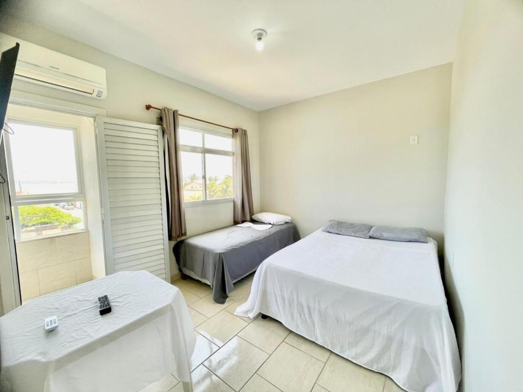 een slaapkamer met twee bedden en een raam bij Pousada Shalom Adonai-1 in Guarapari