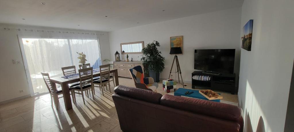 een woonkamer met een bank en een tafel bij La maison du saule in Yves