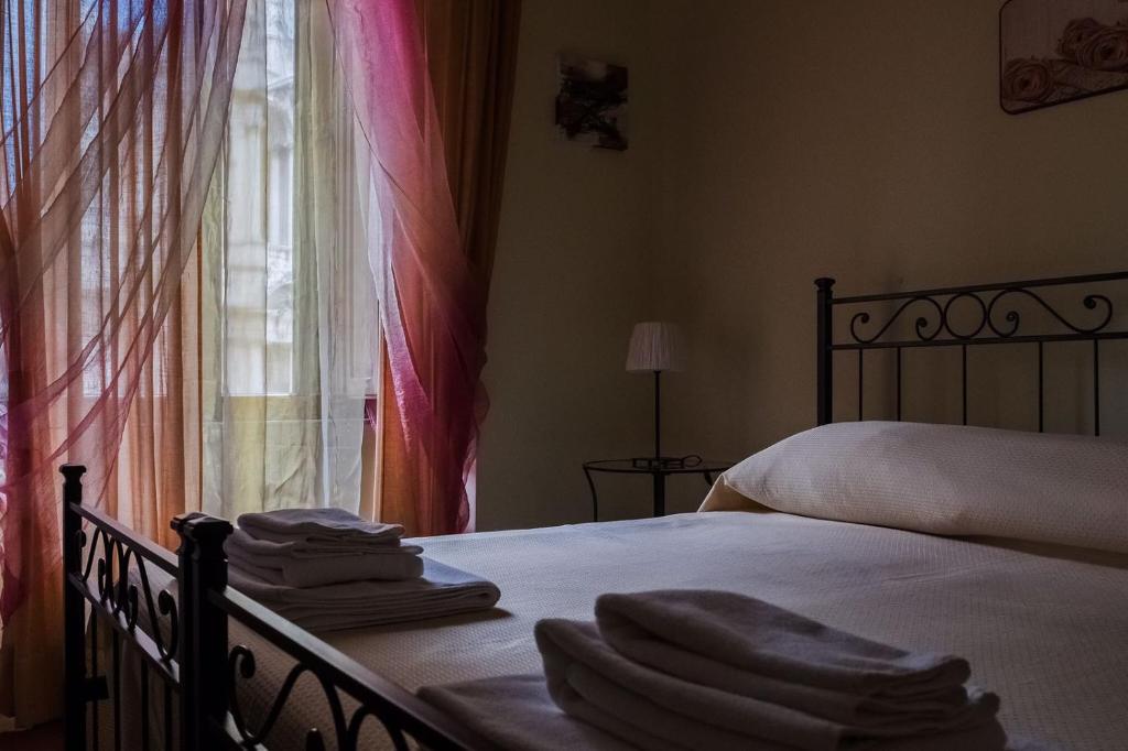 a bedroom with a bed with folded towels on it at Glam Sm Maggiore Guest House in Rome