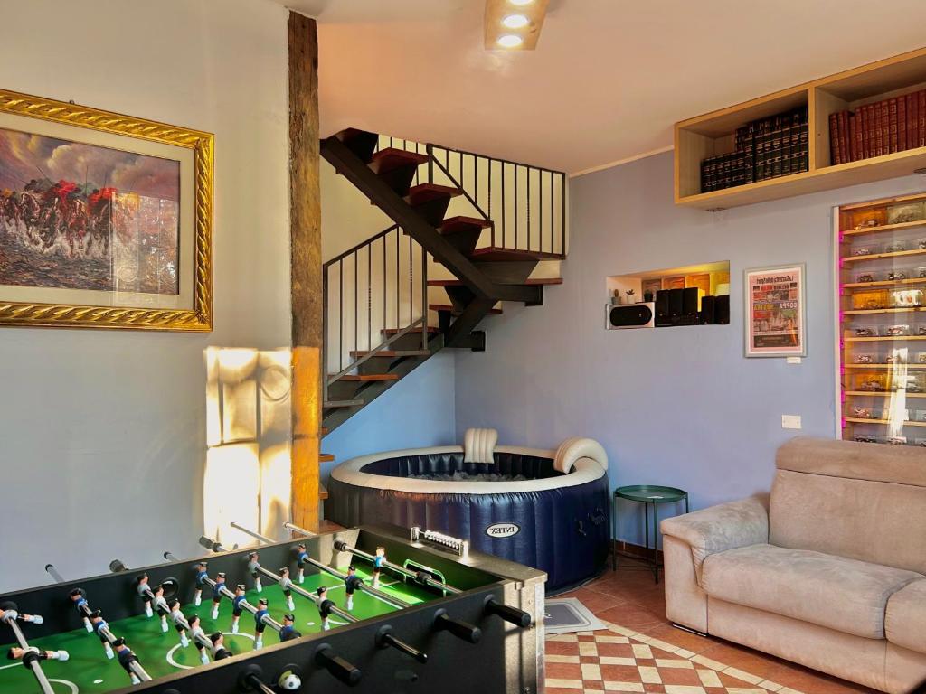 ein Wohnzimmer mit einem großen Billardtisch und einer Treppe in der Unterkunft G House Casa sul Naviglio in Cassina deʼ Pecchi