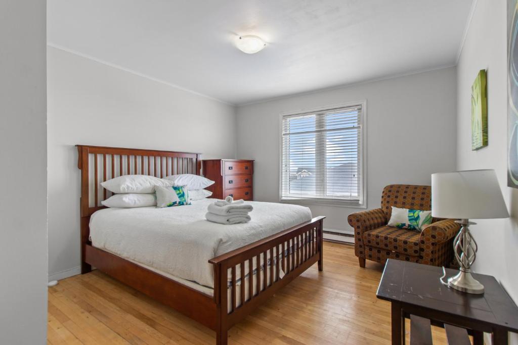 a bedroom with a large bed and a chair at Modern 2BR Suite Parking Laundry in Torbay