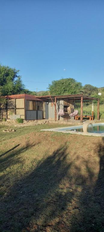 einen Hof mit einem Haus und einem Pool in der Unterkunft Lo de Nor - Refugio de Montaña in San Antonio de Arredondo