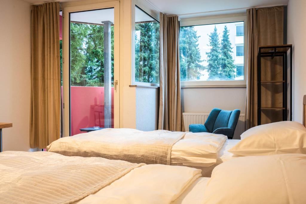 - une chambre avec 2 lits, une chaise et des fenêtres dans l'établissement Luxury Homburg, à Hombourg