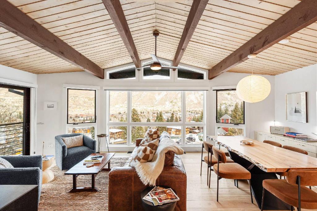 a living room with a wooden ceiling and a table at Shadow Mountain 20 in Aspen