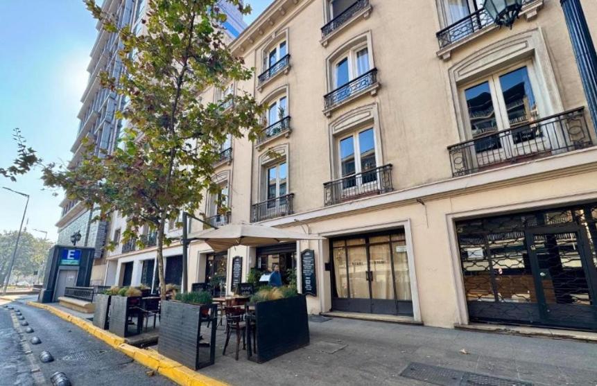 een gebouw op een straat met tafels ervoor bij Apart Merced Home in Santiago