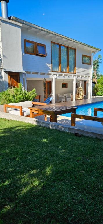 a house with a table and a pool in front of it at Complejo Pelicano Chapadmalal in Chapadmalal