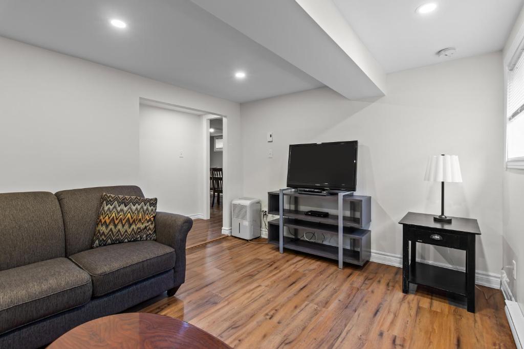 ein Wohnzimmer mit Sofa und Flachbildfernseher in der Unterkunft Stylish 2BR WiFi Parking MUN Walk in St. John's