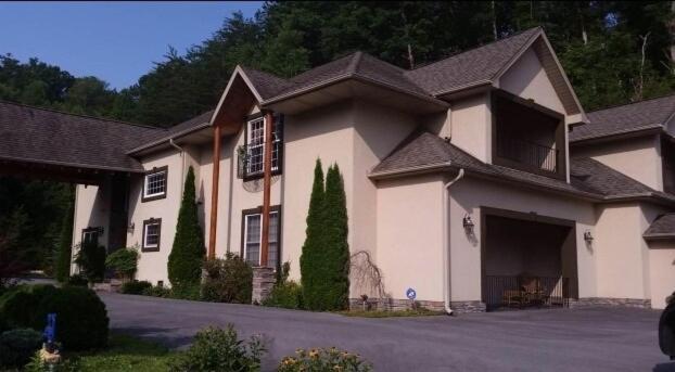 ein großes weißes Haus mit einem schwarzen Dach in der Unterkunft Splash in the Smokys ! in Sevierville