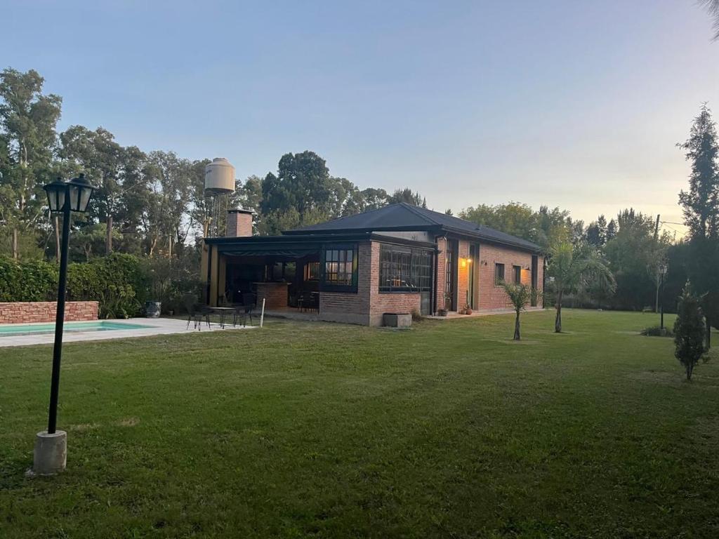 une maison dans un jardin gazonné avec piscine dans l'établissement Casa Quinta La Plata, à La Plata