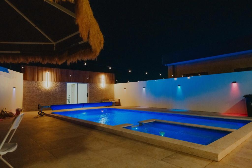 una grande piscina in un edificio di notte di Villamaria a Oranjestad