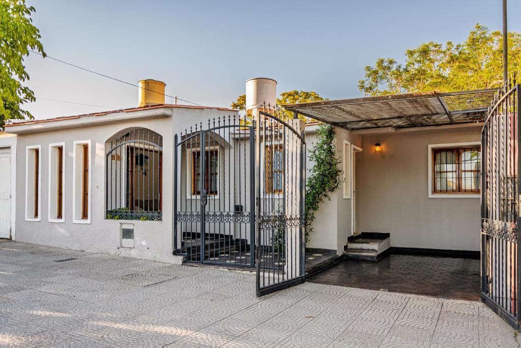 a white house with a gate in front of it at Esencia de Montaña in El Challao