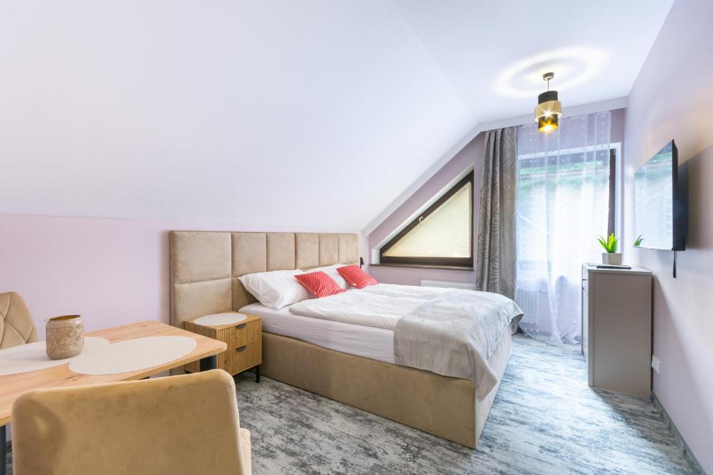 a bedroom with a bed and a desk and a window at Apartamenty Sarnia 6A in Karpacz