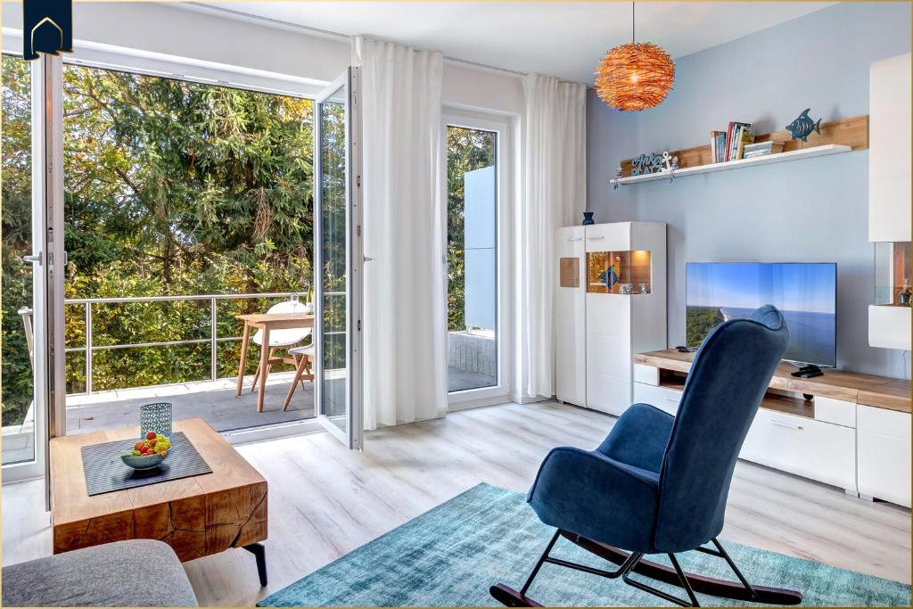 a living room with a blue chair and a desk at Ostseenest Bernstein in Kölpinsee