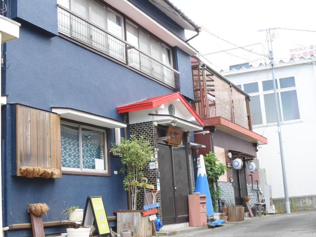 a blue building with a door on a street at Guest House Tokiwa in Fujinomiya