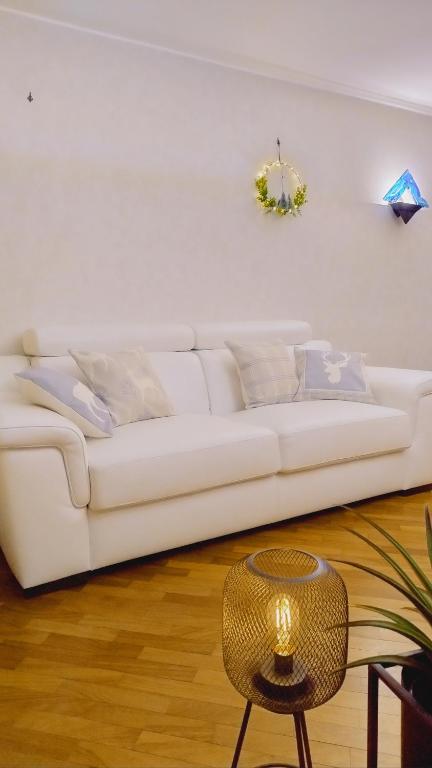 un divano bianco in soggiorno con tavolo di Da NOEMI E MARCO a Cavalese