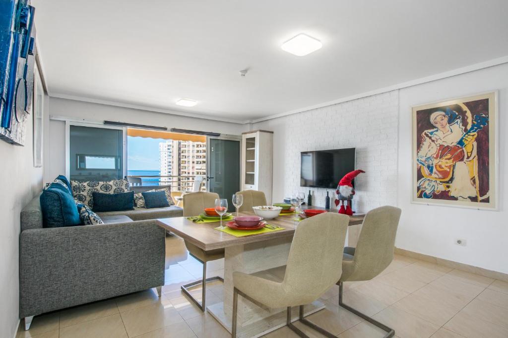 una sala da pranzo e un soggiorno con tavolo e sedie di Magnífico Sol Paraíso ad Adeje