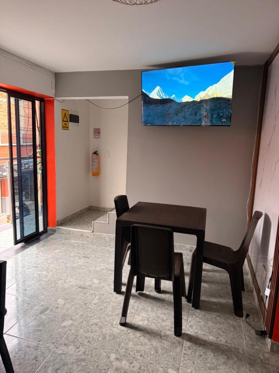 a dining room with a table and a television on the wall at Hotel y Restaurante More in Supía