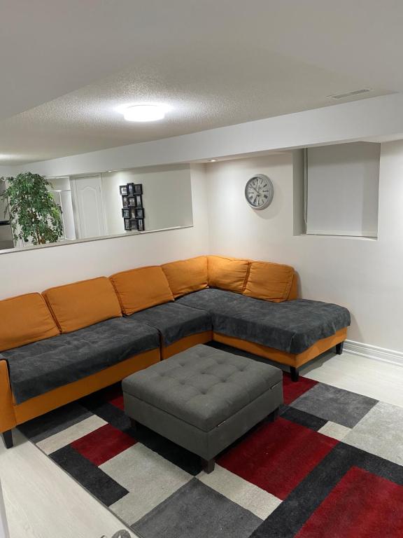 eine Couch und ein Hocker in einem Wohnzimmer in der Unterkunft Akhtar's Residence in Mississauga