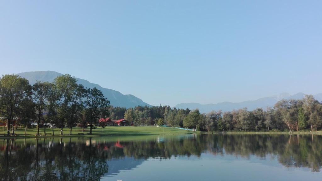 a golf course with a lake and mountains in the background at Ferienhaus Benetik am Sonneggersee in Sittersdorf