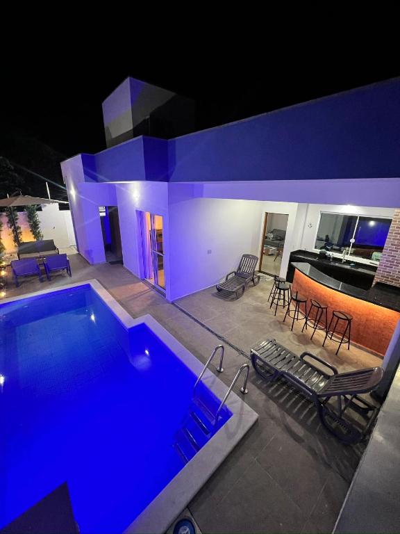 a house with a swimming pool and a piano at Piscina Aquecida Quartos com Ar cond 700m Praia in Peruíbe
