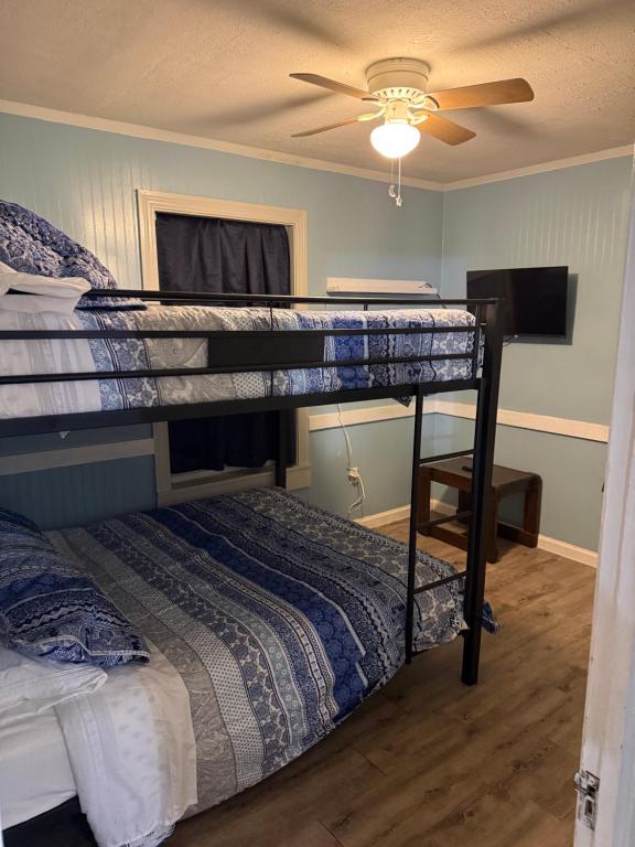 1 Schlafzimmer mit 2 Etagenbetten und einem Deckenventilator in der Unterkunft Quaint Getaway in Pascagoula
