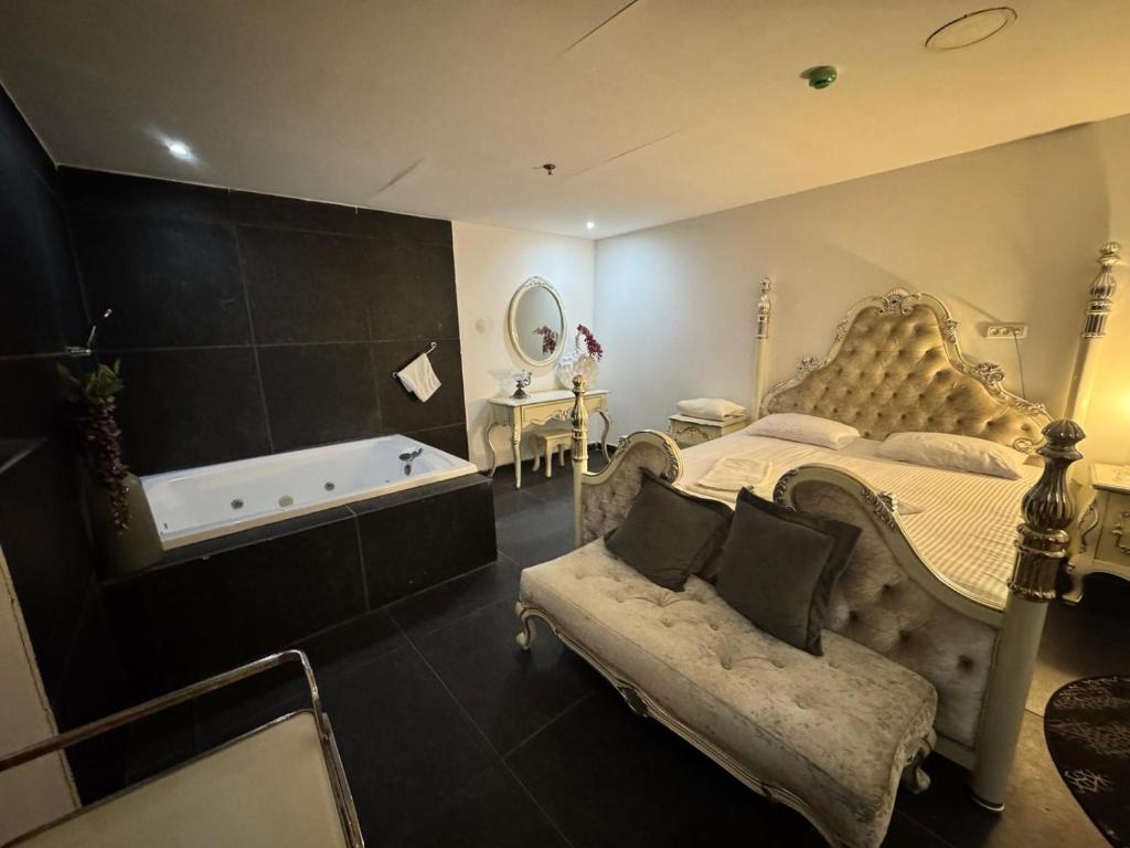 una camera da letto con un letto grande e una vasca da bagno di Shantel a Haifa