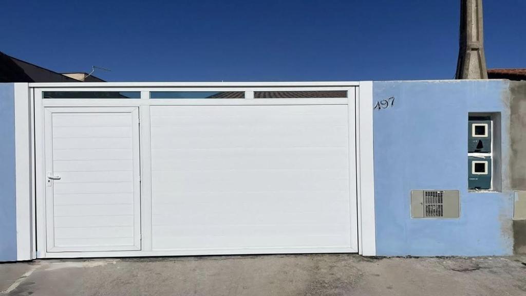 een witte garagedeur met een bord erop bij Casa Ilha comprida 2 quartos yemar in Ilha Comprida