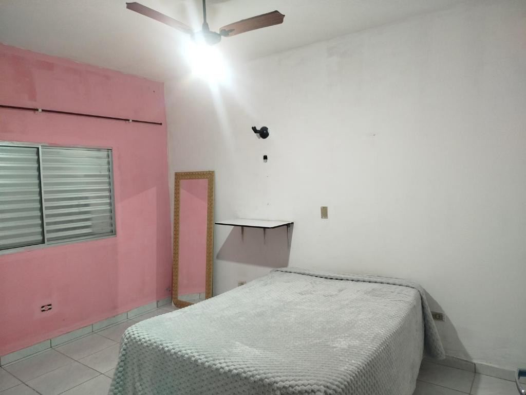 una camera con letto e porta rosa di Casa da Cris a Itanhaém