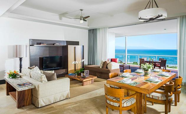 een woonkamer met een tafel en uitzicht op de oceaan bij Vidanta 2-bdrm Villa, in Nuevo Vallarta 