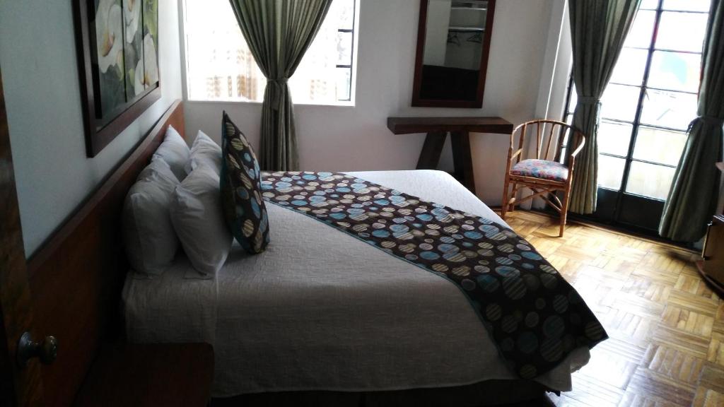 ein Schlafzimmer mit einem Bett mit einem Regenschirm darauf in der Unterkunft Hotel Bella Montaña in Manizales