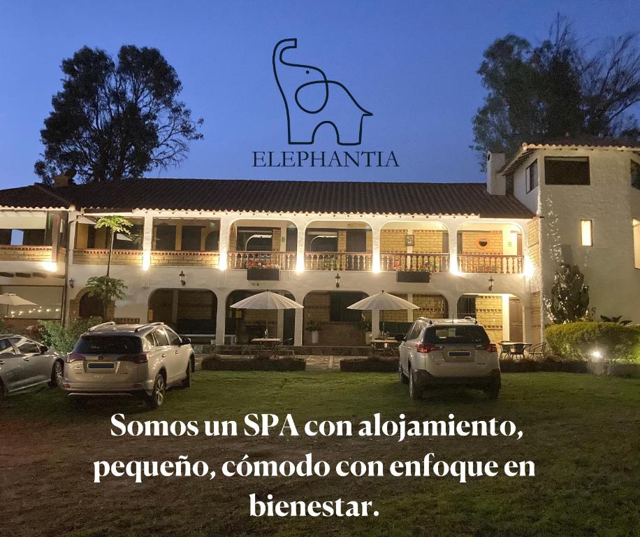 een gebouw met daarvoor geparkeerde auto's bij Elephantia Spa Hotel in Villa de Leyva