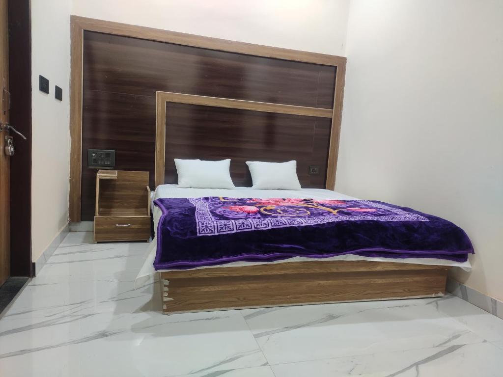 a bedroom with a large bed with a wooden headboard at Naval Kishori Kunj in Vrindāvan