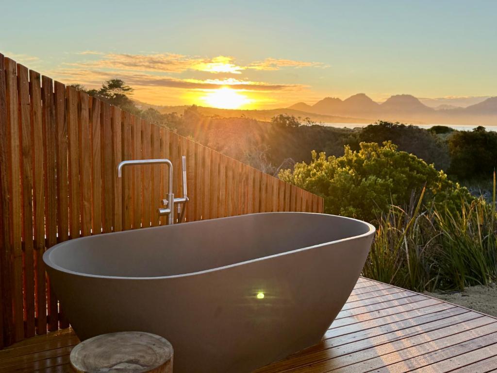 een ligbad op een houten terras met zonsondergang bij Studio Tasmania in Dolphin Sands