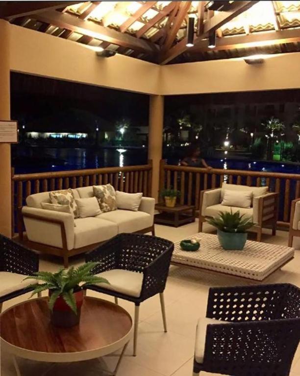 a living room with a couch and chairs and a table at Vg Sun Cumbuco Beach House in Caucaia