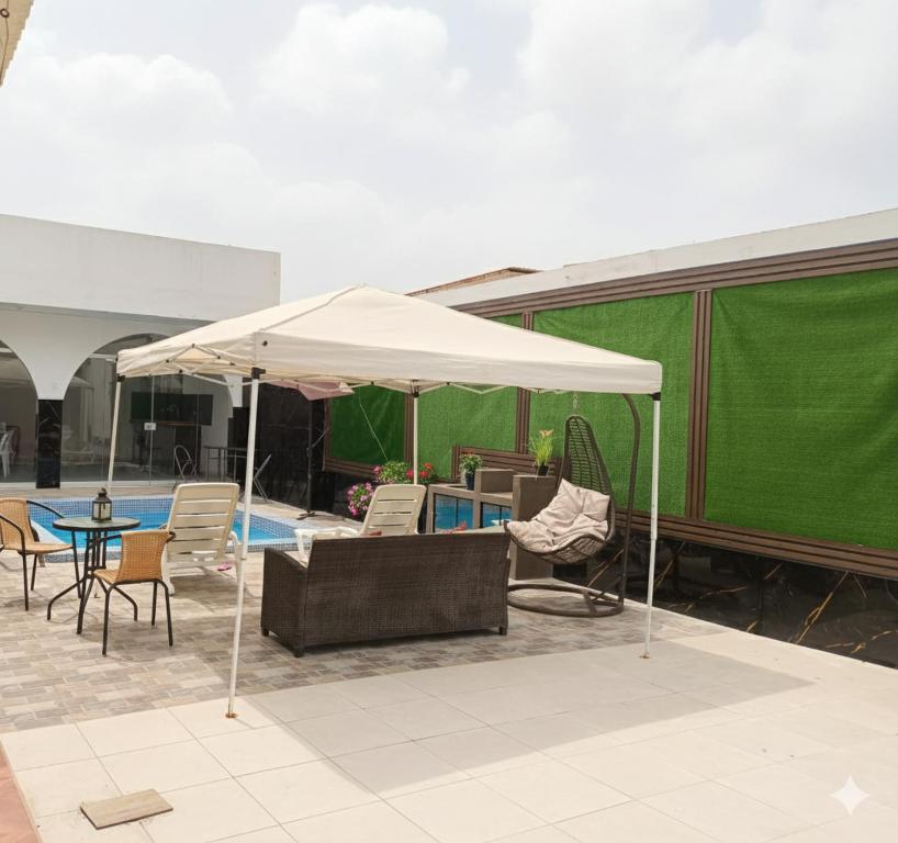 een witte parasol op een patio met stoelen en een tafel bij la punta nueva en Camaná in La Punta