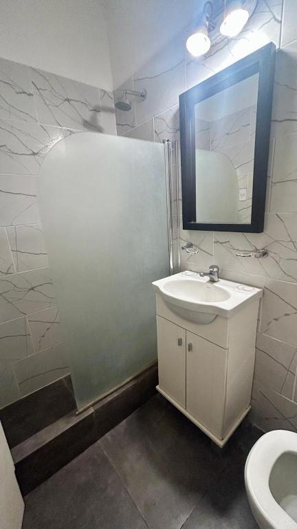 a bathroom with a sink and a mirror and a toilet at Satya park in Mar del Plata