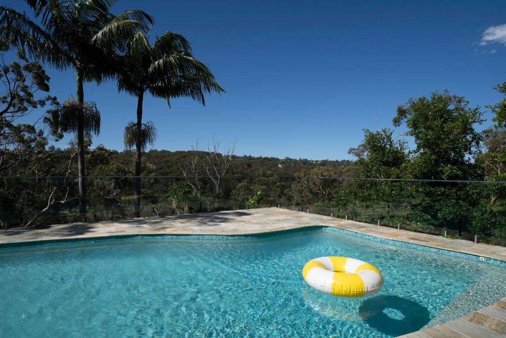 a swimming pool with two beach balls in the water at Garigal Retreat with Pool access and EV Station in Forestville