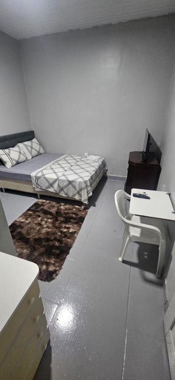 a room with a bed and a desk and a chair at Boa opção in Manaus