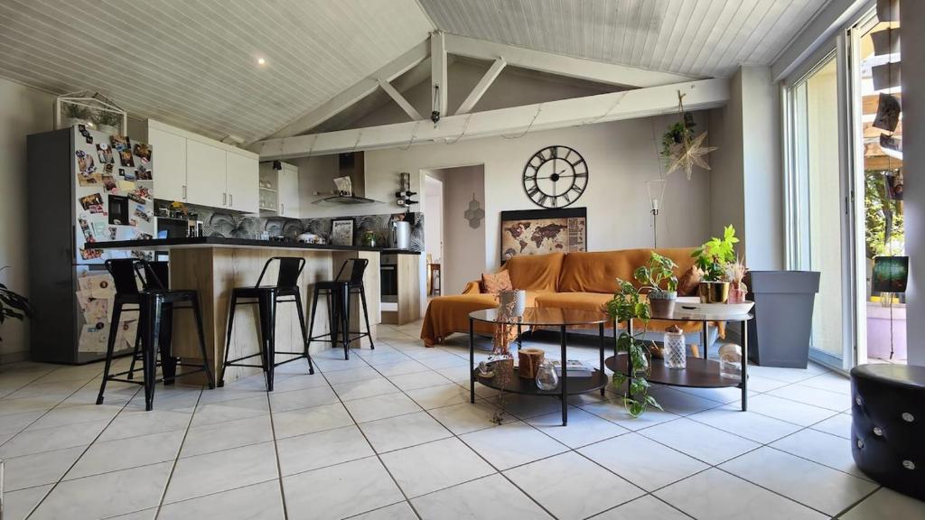 a living room with a couch and a table at Charmante maison t3 avec 2 chambres et jardin clos in Carquefou