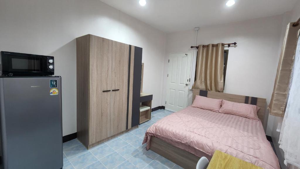 una piccola camera con letto e frigorifero di หลังมอ บิวตี้ อพาร์ตเมนต์ เปลี่ยนชื่อเป็นหลังมอ อพาร์ทเมนท์สามสาว ห้องพักจะอยู่ในทาวเฮ้า2ชั้น เเจ้งเปลี่ยนที่พัก a Ban Hua Khwai