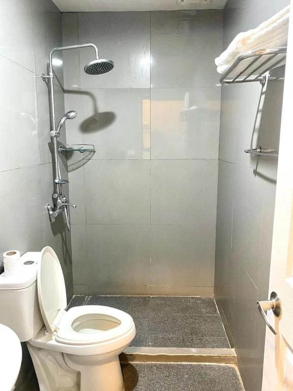 a bathroom with a toilet and a glass shower at Shine Hotel in Sampong