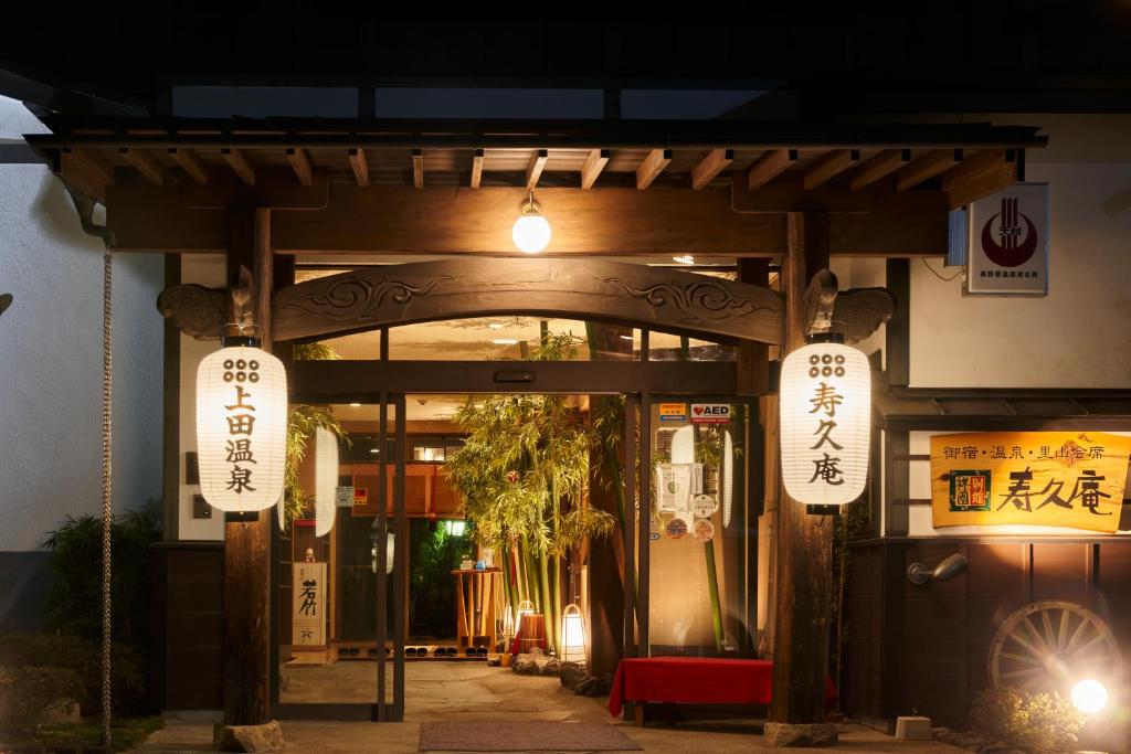 een toegang tot een gebouw 's nachts met verlichting bij uedaonsen jukyuan in Ueda