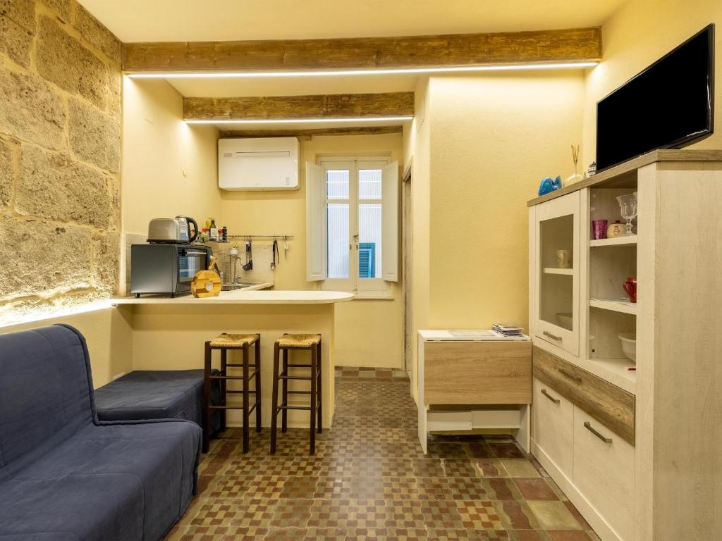 a living room with a couch and a kitchen at Monolocale in centro storico in Alghero