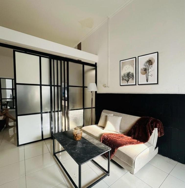 a living room with a couch and a table at Spacious House - Ngemplak, Surakarta in Kadipiro